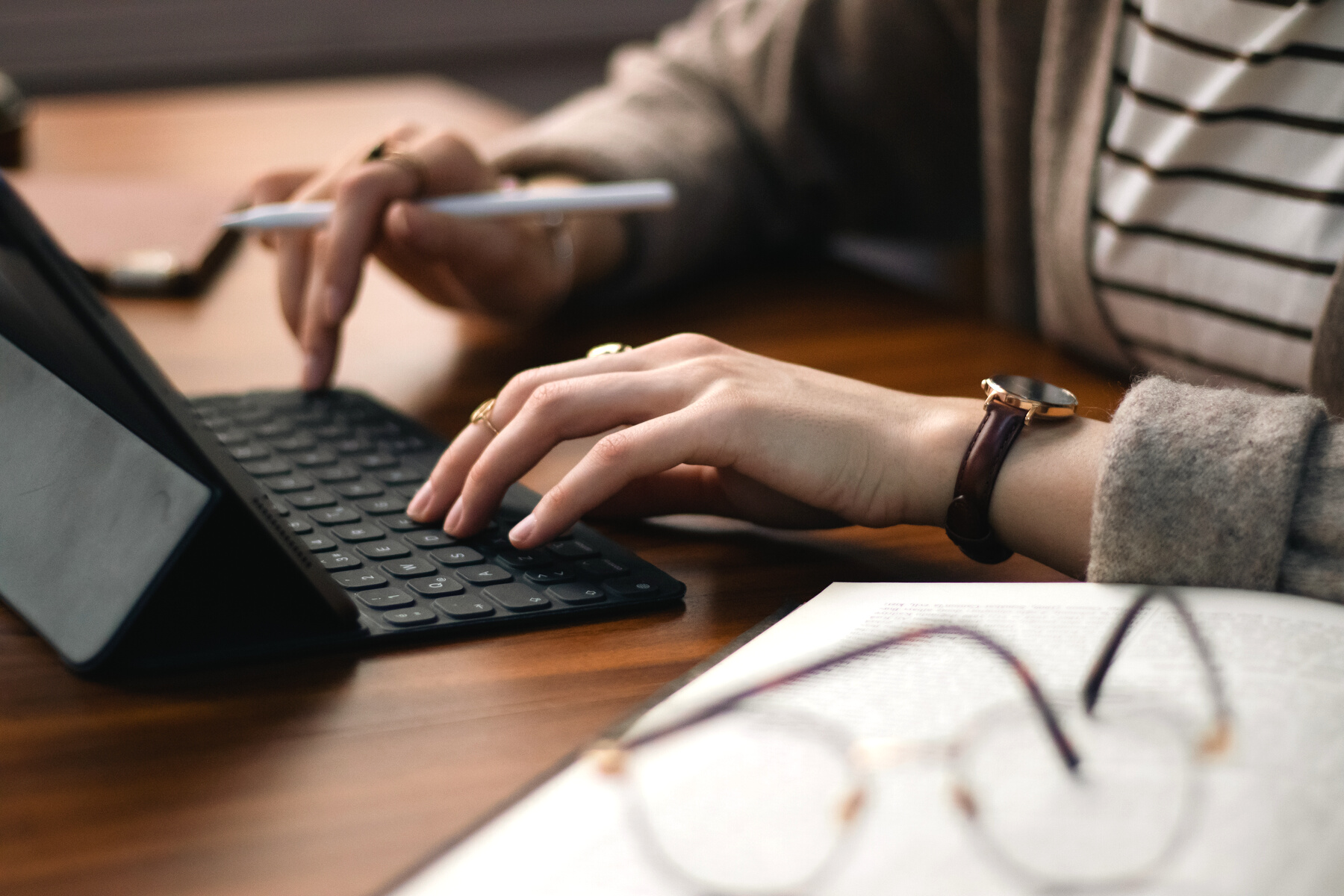 Woman Typing on Tablet in Library